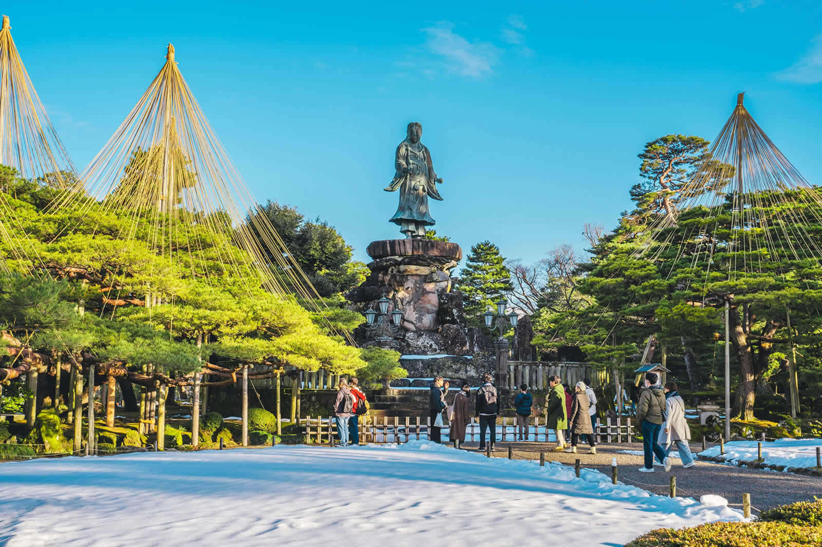 冬の金沢、雪吊りと像が日差しに照らされる風景